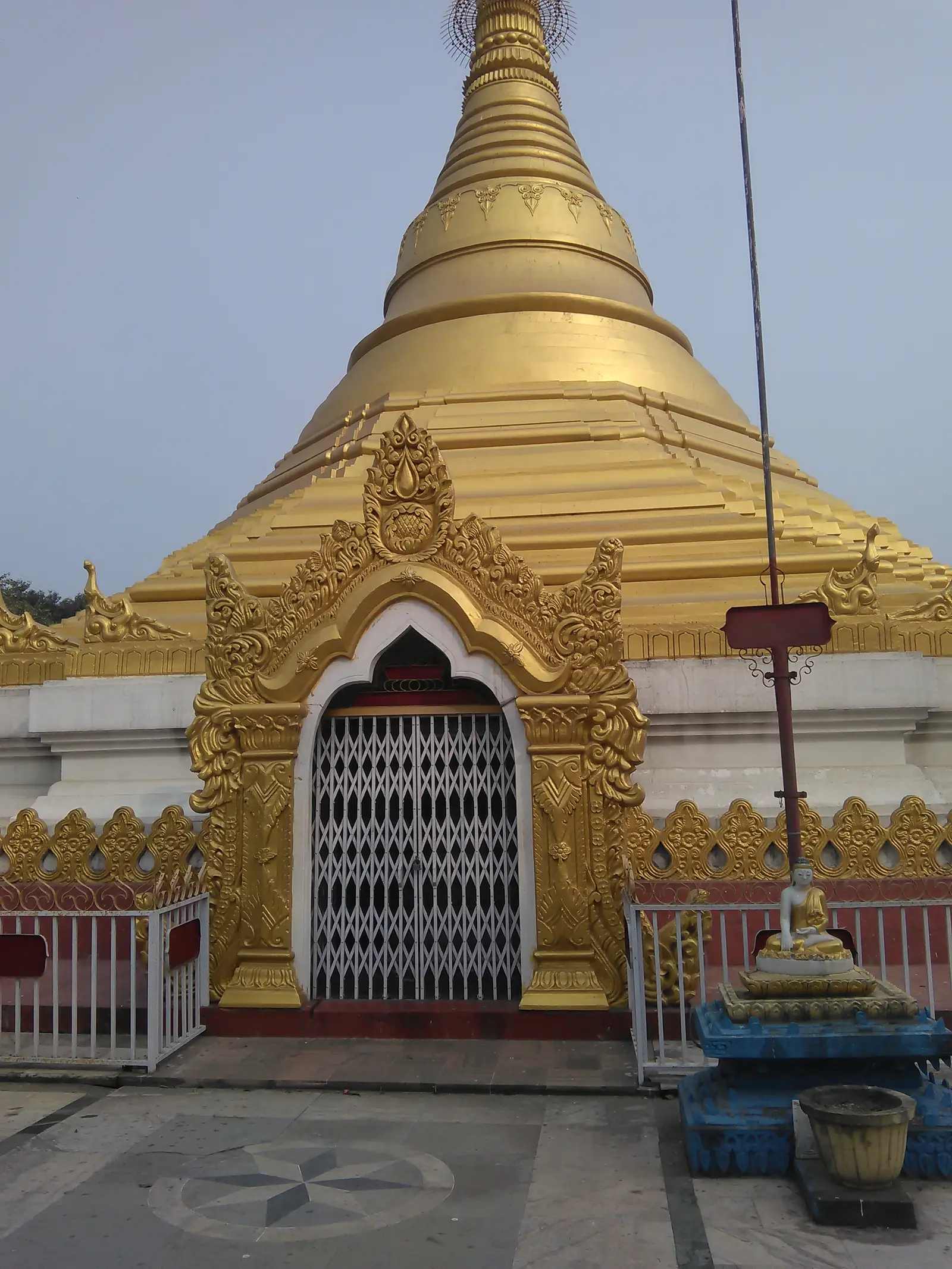 The golden pagoda of Dhamma Janani Vipassana centre in Lumbini, with an ornate arched doorway at its base