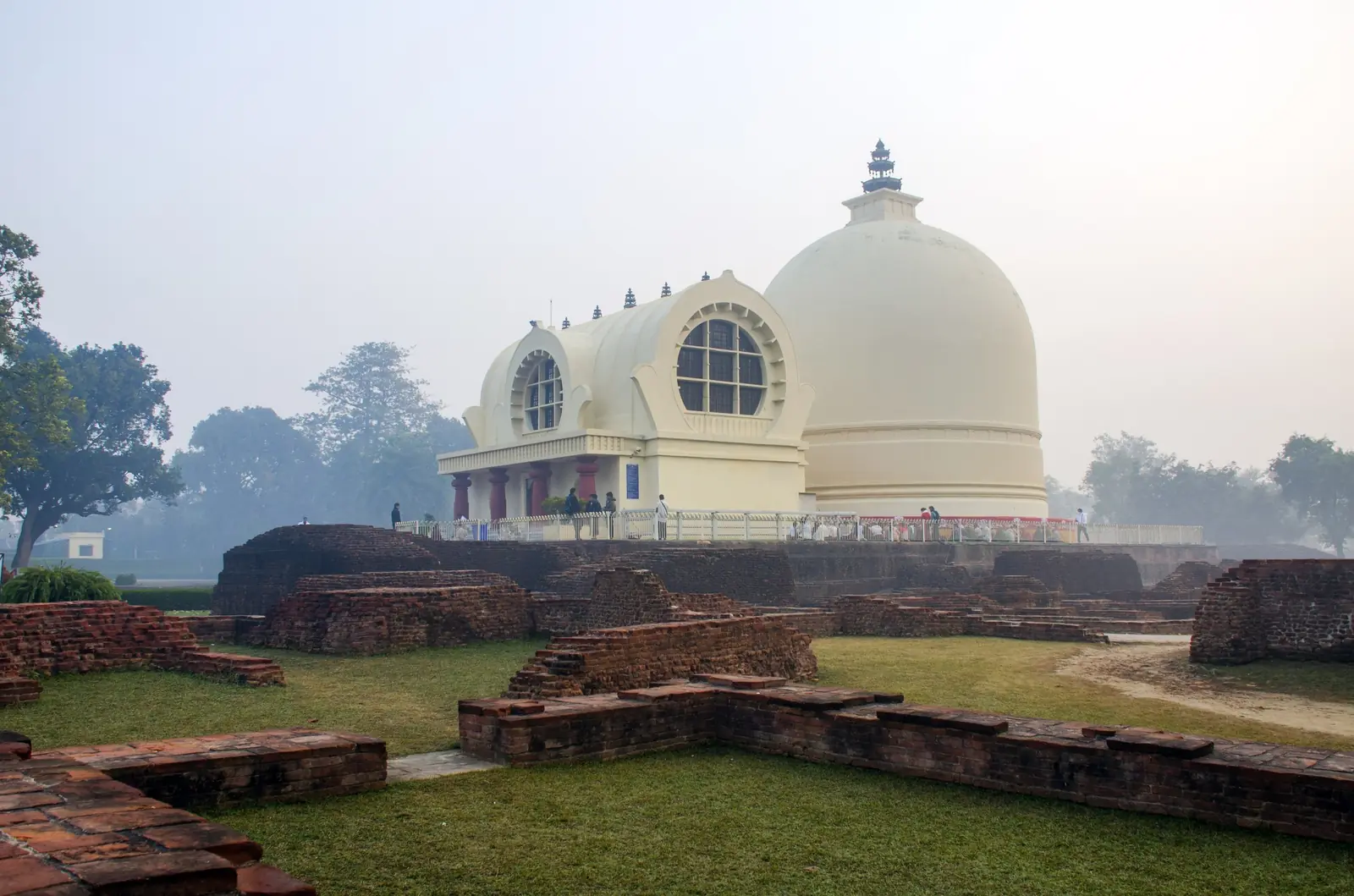 The Mahaparinirvana Temple and stupa at Kushinagar on a misty morning, seen across ancient brick ruins