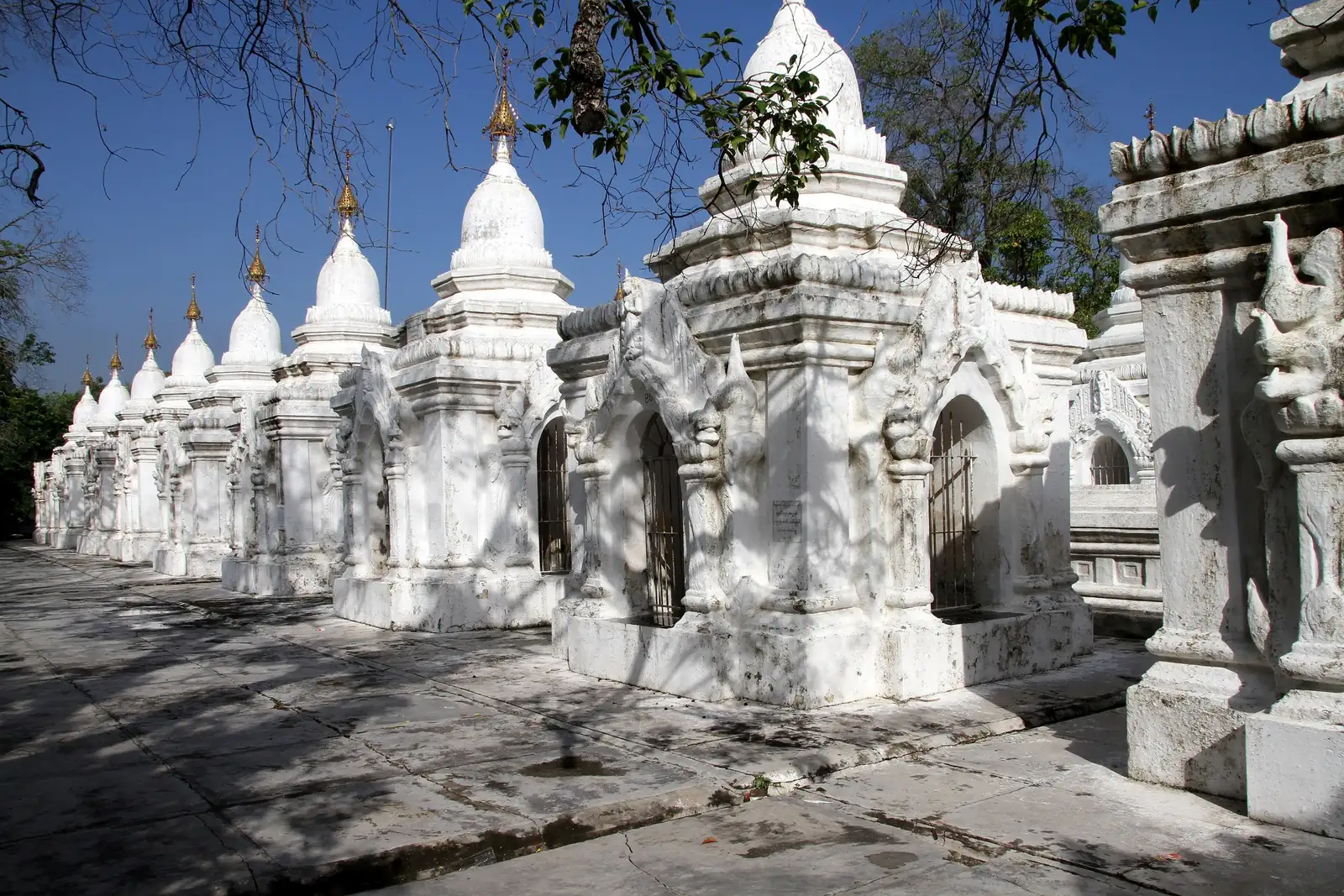 Rows of small white shrines at Kuthodaw Pagoda, Mandalay, each housing a marble slab inscribed with part of the Pali Tipitaka