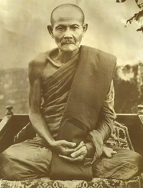 Sepia portrait of Ajahn Mun Bhuridatta, an elderly Thai forest monk seated cross-legged with hands folded in his lap