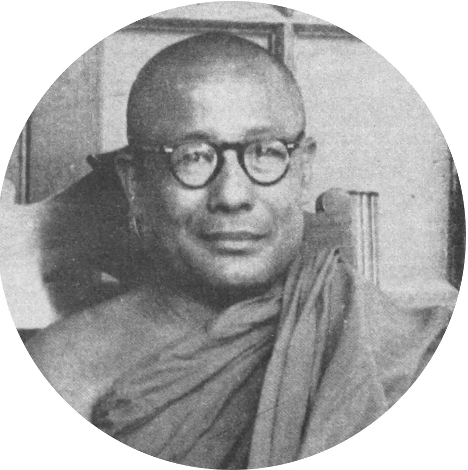 Black-and-white head-and-shoulders portrait of a young Sayadaw U Pandita wearing round glasses, in a circular frame