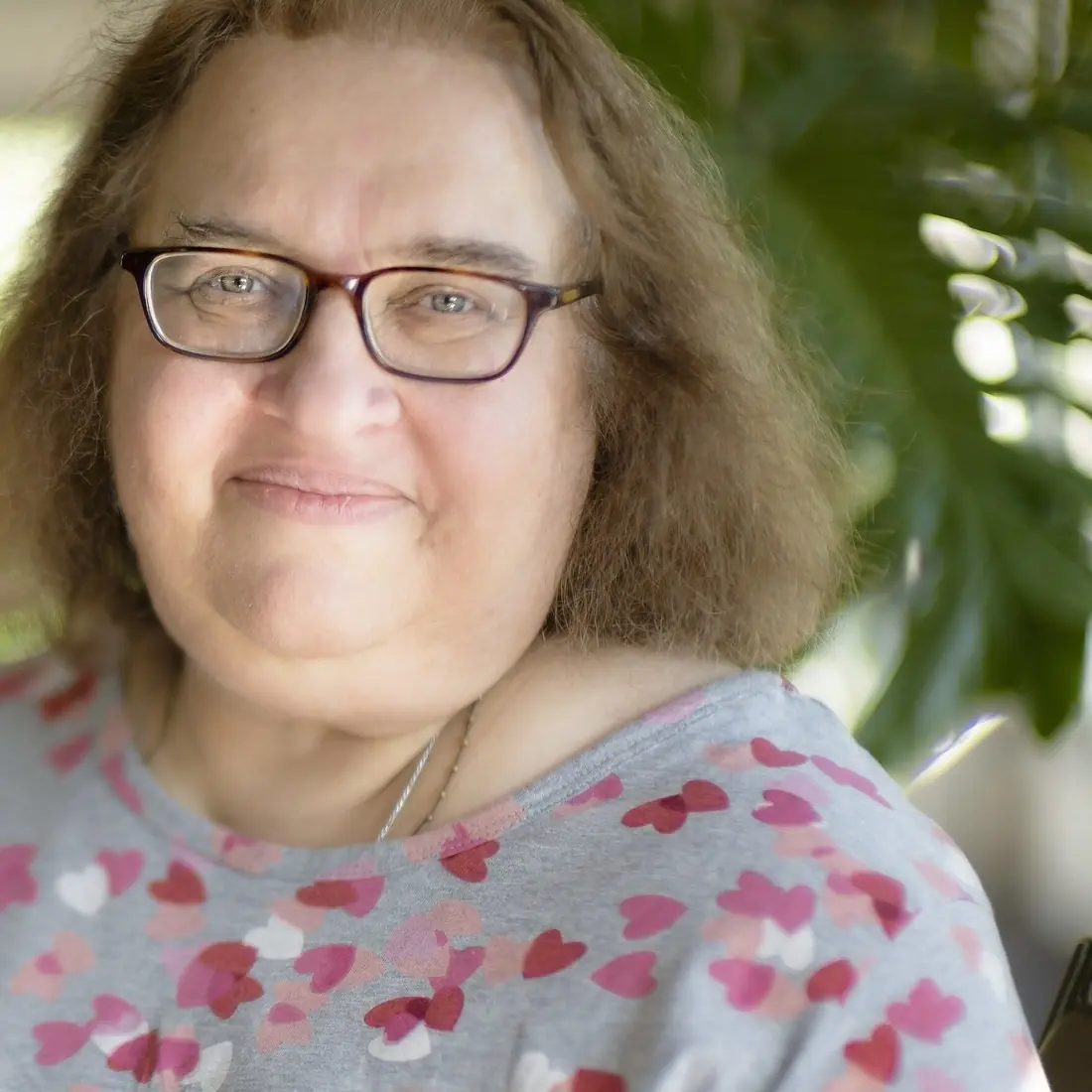 Sharon Salzberg, smiling, with shoulder-length hair and glasses